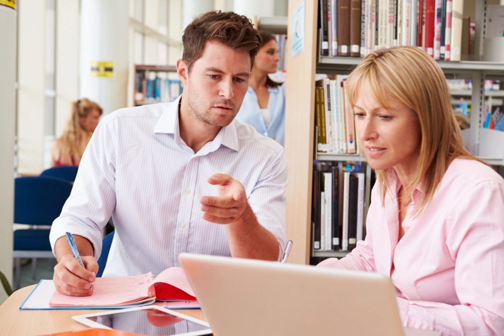 A man and woman looking at a laptop.