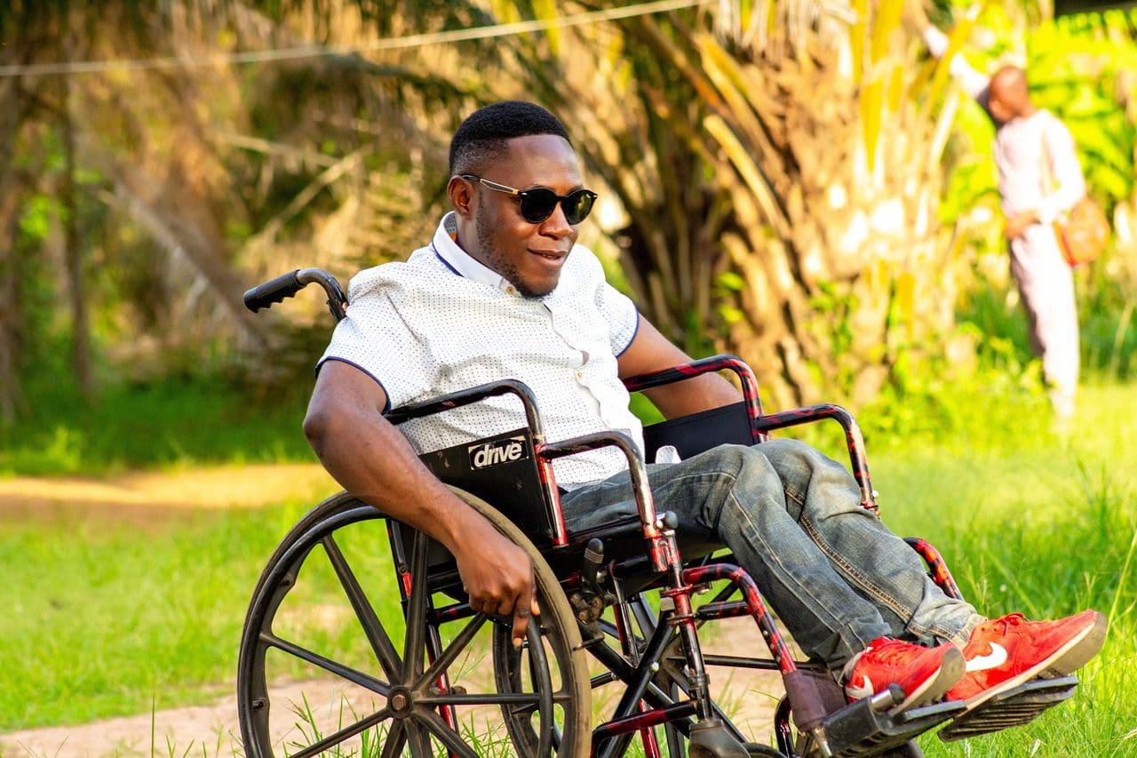 A man in a wheelchair with sunglasses on.